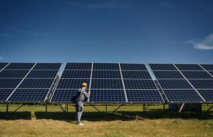 Rear ,view, the maintenance. Engineer with photovoltaic solar panels outdoors at daytime photo