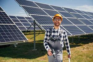 Ready to, work, with drill. Engineer with photovoltaic solar panels outdoors at daytime photo