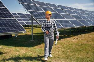 Ready, to work, with drill. Engineer with photovoltaic solar panels outdoors at daytime photo