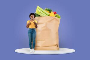 A customer stands smiling with a paper bag filled with fresh groceries, including produce, showcasing the new normal of shopping. The background highlights a vibrant color scheme that adds energy. photo