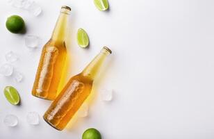 Beer advertisement and evening in pub. Two full transparent glass bottles with ale without labels, with flowing drops, lie with ice cubes and pieces of lime, on white background, free space photo