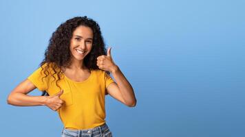 I Like It. Cheerful Brunette Woman Showing Thumbs Up With Both Hands, Recommending Something, Gesturing Sign Of Approval, Posing Over Purple Studio Background, Smiling At Camera, Copy Space photo