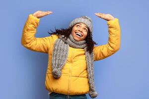 Cheerful Black Girl Pushing Something Up With Raised Hands Or Holding Invisible Object Above Head Standing On Purple Studio Background photo
