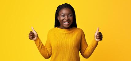 I Like It. Joyful African American Woman In Bright Sweater Showing Thumbs Up At Camera, Positive Black Woman Recommending Something, Gesturing Sign Of Approval, Standing On Yellow Background photo