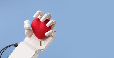 Life and robotics concept. Robot hand holding red heart, blue panorama background with empty space photo