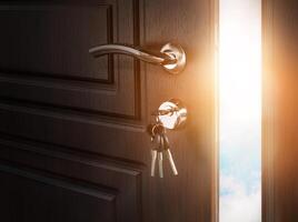 Half open door with keys in keyhole. Doorway to heaven and success. Entrance or exit, dreams and freedom conceptual background photo