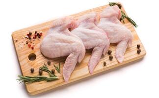 Raw chicken wings with spices for cooking on a wooden cutting board photo