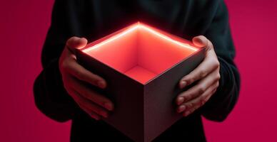Hands hold an open delivery box with a glowing red interior against a vibrant background. The moment captures curiosity and anticipation as the contents remain unseen. photo