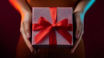 Hands present an open gift box adorned with a red ribbon against a vibrant background. The moment captures the excitement of sharing a package, highlighting joy and anticipation during delivery. photo