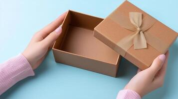 A pair of hands gently opens a delivery box, revealing its empty interior. The cozy setting features a soft blue background, enhancing the anticipation of what is inside the parcel. photo