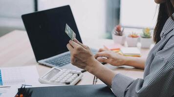 A woman is holding a credit card while sitting at a desk video