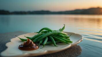 Green Beans and Dip on Plate by Lake at Sunset photo