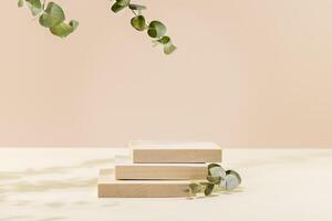 Empty square product display on pink background with green eucalyptus leaves photo