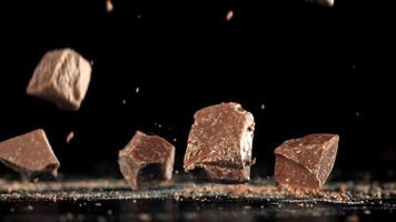 Pieces of chocolate fall on the table. Filmed on a high-speed camera at 1000 fps. High quality FullHD footage video
