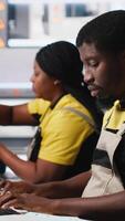 Vertical Black employee manages solar panel configuration via desktop tools, optimizing factory output and troubleshooting. Technician updates energy system parameters on pc. Camera A. video