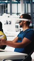 Vertical Photovoltaics factory engineer designing on PC CAD software with VR headset, working in solar panels manufacturing plant. Black specialist inspecting assembly lines in virtual reality. Camera B. video