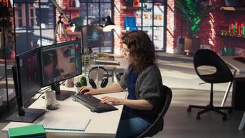 Female editor designer retouches photos on dual monitors desktop, computer setup in a creative office. Ideal workspace for digital media professional focused on photo editing. Camera A. video