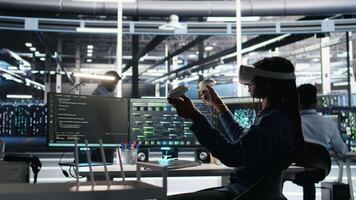 Data center technician using virtual reality tech and node tree software to analyze datasets. Server room expert using visual programming tools and VR equipment to improve gear performance, camera A video