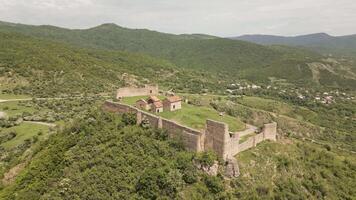 Aerial panning view Manavi Fortress Complex. A Medieval Royal Stronghold. Strategic Hilltop Citadel Overlooking Iori Valley in Kakheti, Georgia. Hidden gem sightseeing off the beaten path attraction video