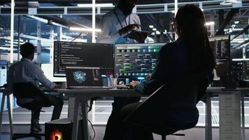 Server hub manager talking with programmer using node tree software to optimize system health. Data center supervisor overseeing IT expert analyzing equipment issues using AI visualization, camera A video