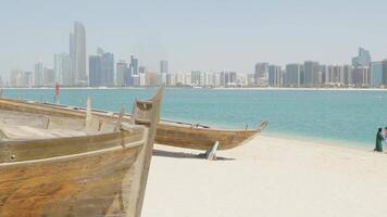 Romantic scene of couple walking or relaxing on a beach with the stunning modern skyline of Abu Dhabi in the background. A blend of fun, cityscape, and coastal beauty in the UAE. video