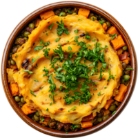 Overhead View of a Hearty Shepherd's Pie with Golden Mashed Potato Topping on a Round Wooden Bowl with Green Peas and Orange Carrots Garnished with Fresh Parsley png