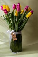 HELLO SPRING card Bouquet of colorful tulips in vase in pastel green background. Copy space for greeting card. Holiday flowers springtime atmosphere photo