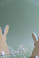 Defocused background Wooden minimalism low-key bunny decor in pastel green background. Sustainable holiday minimalistic still life composition. Copy space template for invitation greeting card postcard photo