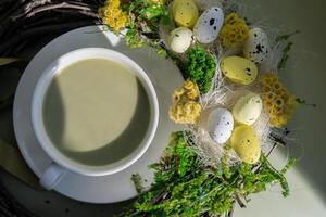 Easter egg wreath holiday decor Nutrient-rich matcha drink with macaron dessert and trendy deep shadows on soft colored background. Morning beautiful breakfast present gift idea. Vibrant creative colors. Natural energy givers tea photo