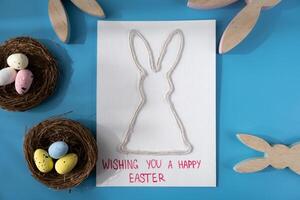 Handmade greeting card with EASTER bunny HAPPY EASTER written in beautiful handwriting. Gesture shows excitement and joy for the upcoming event. Springtime holiday gift present zero cost ideas. Creative art preparation photo