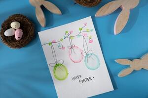 Handmade greeting card with EASTER eggs HAPPY EASTER written in beautiful handwriting. Gesture shows excitement and joy for the upcoming event. Springtime holiday gift present zero cost ideas. Creative art preparation photo