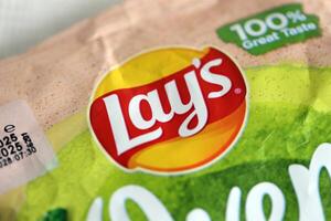 KYIV, UKRAINE - APRIL 19, 2025 Lays Oven Baked Yoghurt with herba flavoured potato chips in green pack with Lays logo photo