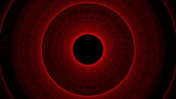Abstract glowing red circular tunnel with concentric rings and a dark center on a black background video