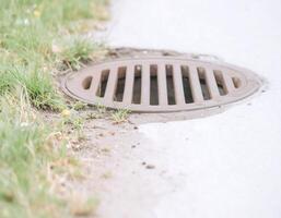 Close-Up of Drainage Grate on the Side of the Road photo