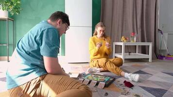 couple having fun playing board game while relaxing video