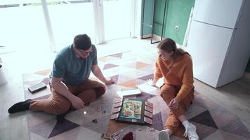 smiling couple having fun playing board game while relaxing and enjoying leisure time together at home video