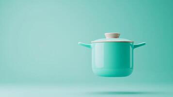 Colorful turquoise pot floating against a soft mint background, highlighting modern kitchen design and innovative cookware ideas photo