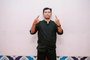 Man pointing upwards in dark shirt providing visual direction photo