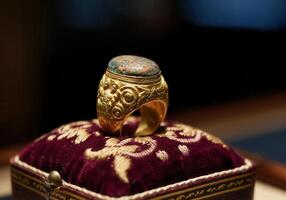 Closeup of an ancient, gilded ring the Ring of the Fisherman on a velvet cushion. photo