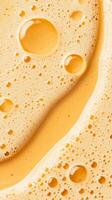 Golden liquid surface with bubbles and foam. Oily texture with circles and shapes. Abstract background. Soft light. Sweet honey color photo