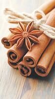 Cinnamon sticks tied with string. Star anise on a wood surface. Close up of spices. Warm brown tones photo