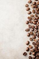 Roasted coffee beans arranged on right side of image. Beige textured surface. Empty space to left. Close up coffee background photo