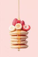 Stack of Pancakes Topped with Sliced Banana Strawberries Raspberries. Syrup Drizzles Down. Sweet Vegetarian Dessert on Pink Background. Delicious Food. photo