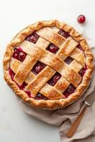 Baked dessert with lattice crust filled with fruit. Golden pie placed on a linen fabric ready to eat. Vegetarian dessert. photo