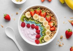 Vibrant breakfast bowl with fresh fruits and granola on white table photo