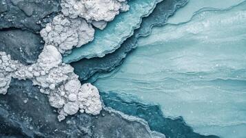 Abstract teal layers and gray rocks collide. White granular deposits rest on rough textured surface. Overhead perspective of natural earthy mix. photo