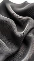 Gray fabric waves softly. Mesh texture detail. Dark flowing material forms gentle folds. Fine interwoven pattern catches light. Close up look at textile surface. photo