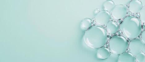 Clear bubbles cluster together on light blue surface. Group of shiny translucent spheres. Spherical shapes create patterns on clean backdrop. Fresh concept with copy space. photo