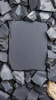 Black slate sits in the center of polished gravel stones, perfect for various applications in garden landscaping and modern home decoration photo