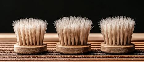 Three wooden brushes with different bristle types lie on a wooden surface, showcasing their design and versatility for various cleaning tasks photo